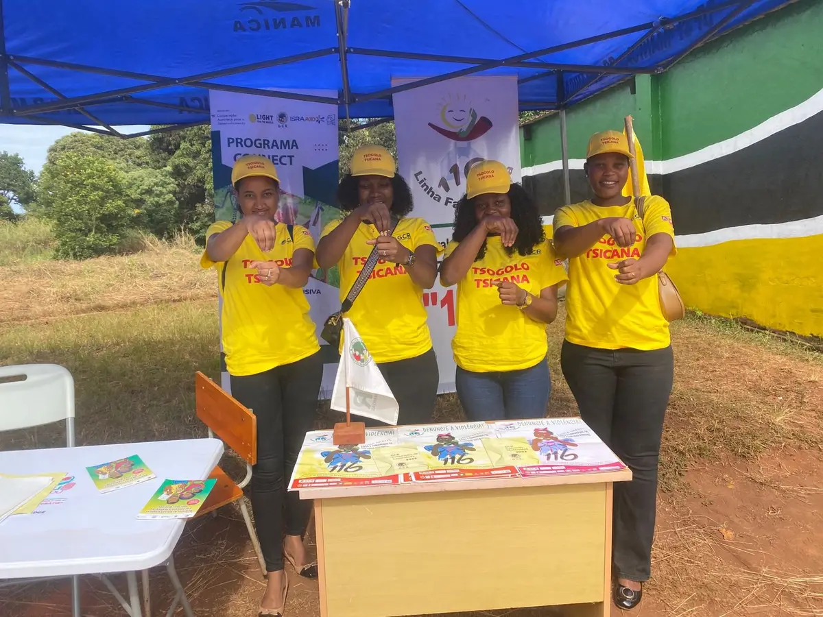 Equipa com camisolas do projecto Tsogolo Tsicana num stand com folhetos de protecção à criança