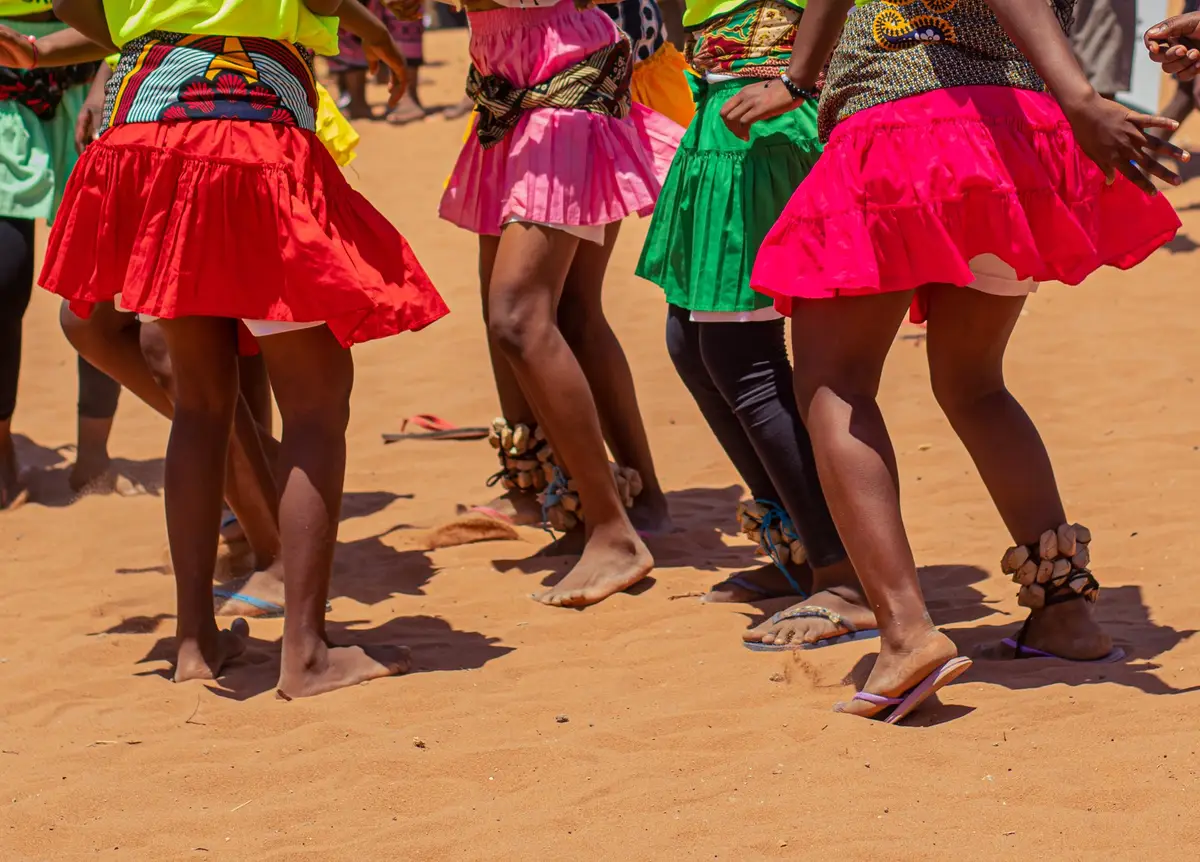 Saias coloridas e pés descalços de raparigas a dançar na areia, num evento SKILLZ